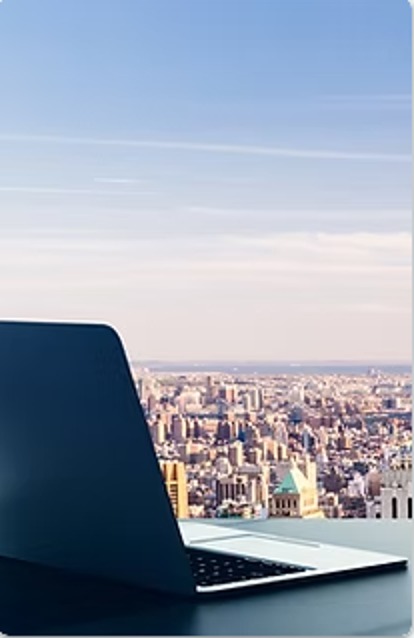 Laptop on a desk overlooking a city skyline